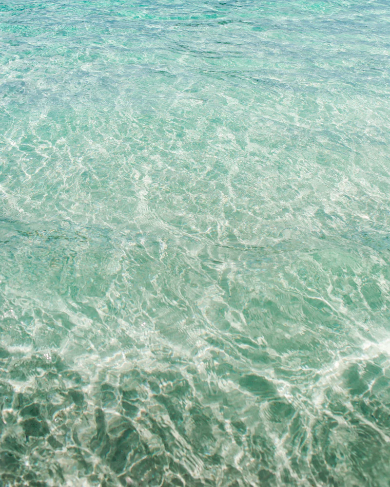 Água rasa e transparente sobre fundo de areia